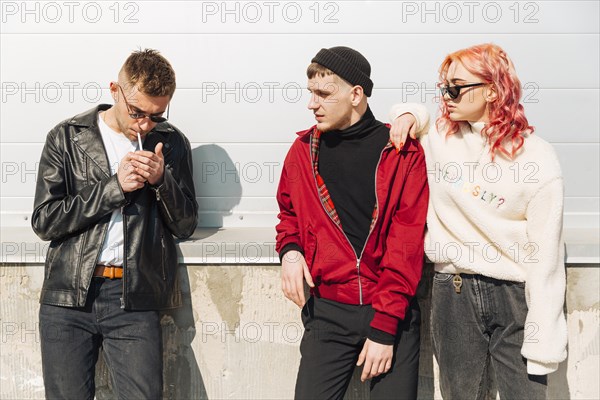 Young couple looking lighting cigarette man