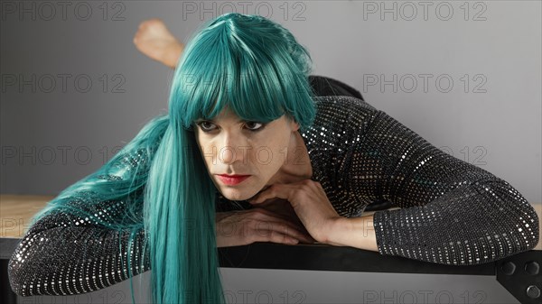 Young transgender person wearing green wig front view