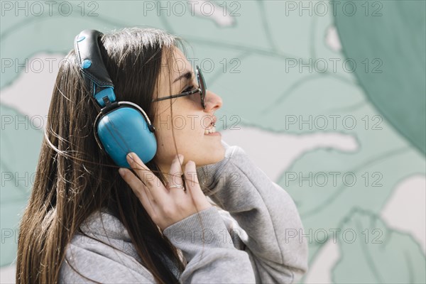 Young woman listening music blue headphones