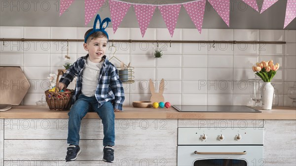 Adorable little boy with bunny ears looking away