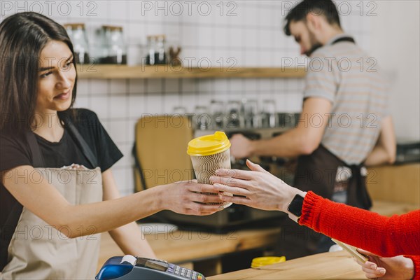 Barista giving drink customer