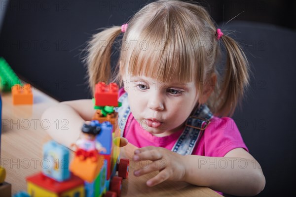 Blonde girl playing with toy train