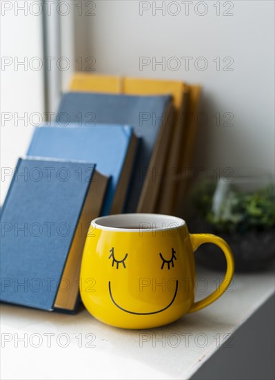 Books arrangement yellow cup
