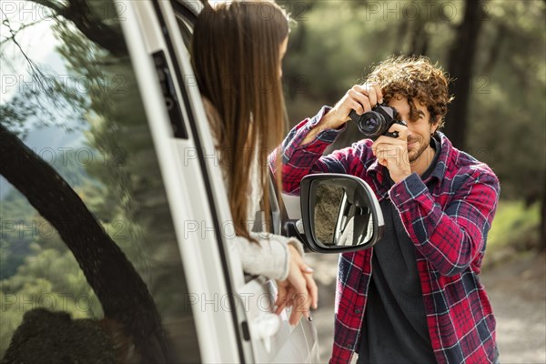 Boyfriend taking pictures girlfriend car while road trip