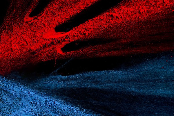 Bright red blue holi powder against black surface