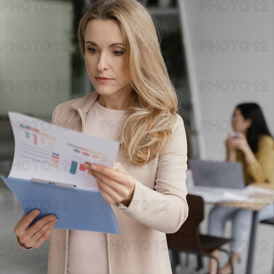 Businesswoman looking through infographics