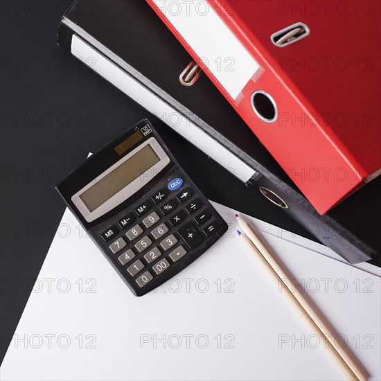 Calculator pencils paper paper files black background