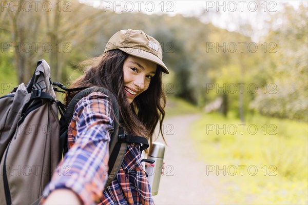 Charming woman with thermos offering tow walk with her