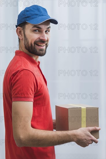 Cheerful courier with sealed parcel