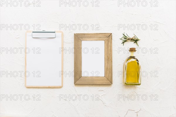 Clipboard wooden frame with oil bottle rosemary herb