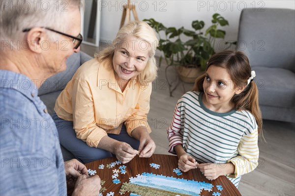 Close up family doing puzzle