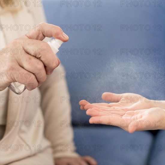 Close up grandma girl using hand sanitizer