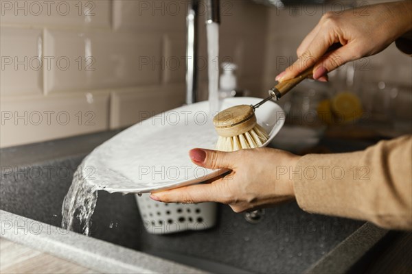 Close up hands cleaning plate