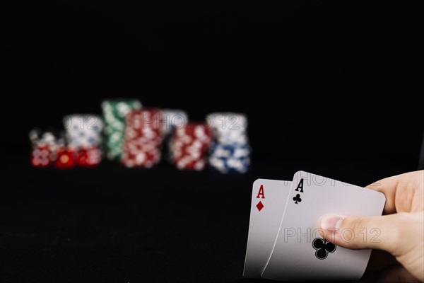 Close up player s hand holding two aces playing cards