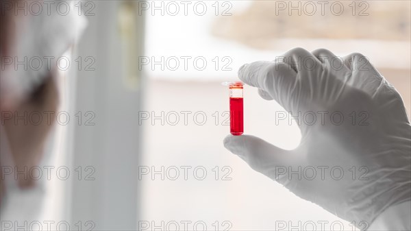 Close up scientist holding tube 2