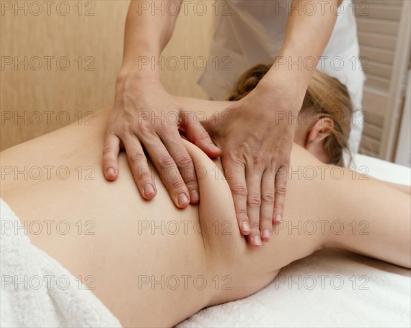 Close up therapist massaging woman s back