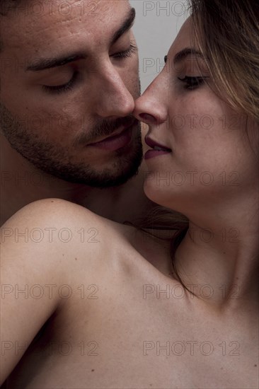 Close up young naked couple kissing