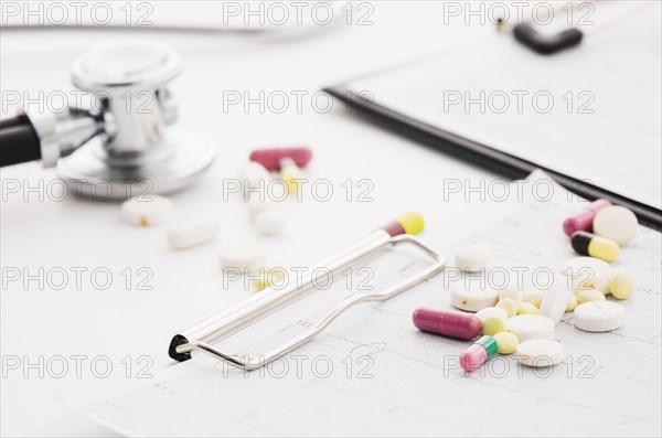 Colorful pills ecg graph stethoscope white background