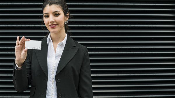 Confident smiling portrait smiling young businesswoman showing white business card