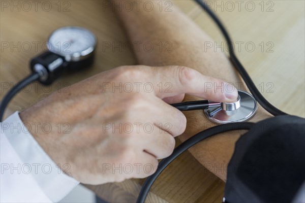 Crop hand measuring blood pressure patient
