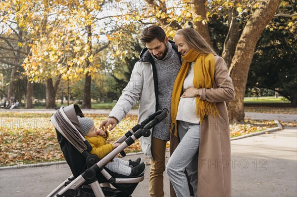 Dad mom with child stroller outdoors