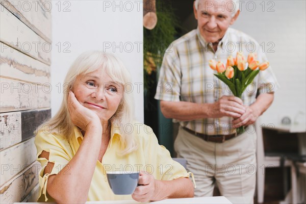 Elderly man standing beloved with flowers