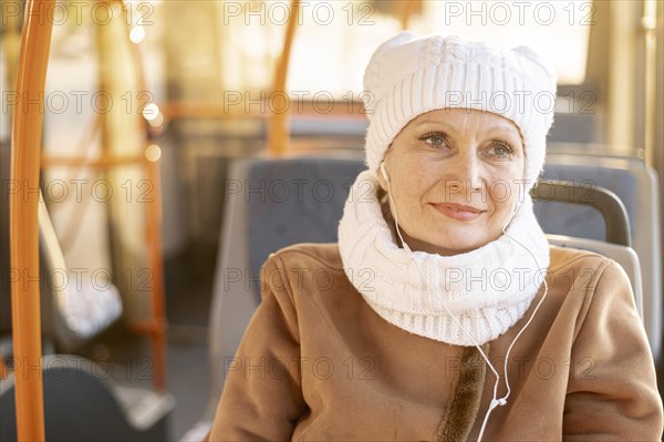 Elder woman bus listening music