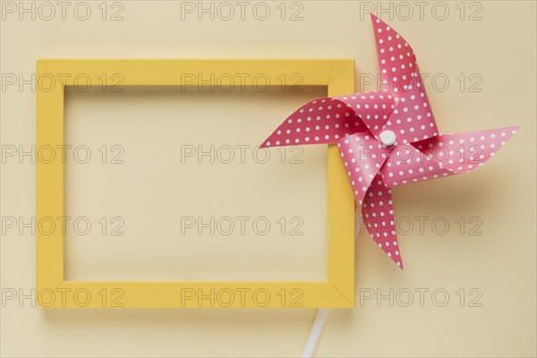 Elevated view dotted pinwheel yellow frame beige background