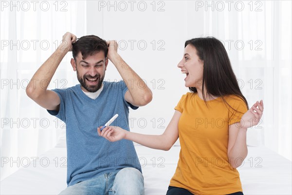 Excited couple holding pregnancy test