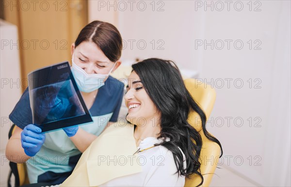 Female dentist showing teeth x ray patient