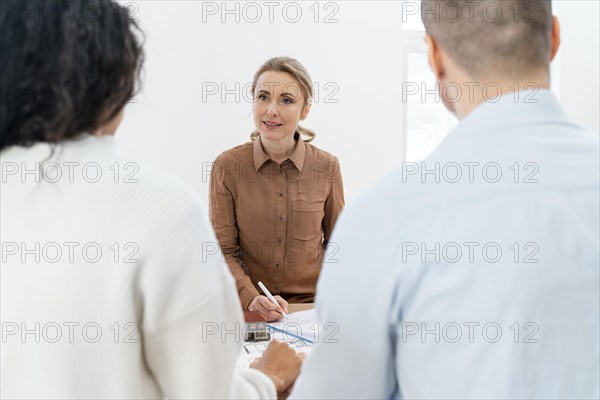 Female realtor signing contract new house with couple