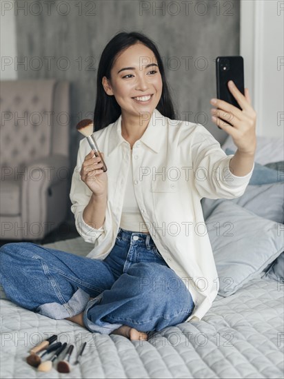 Female vlogger showing her make up brush