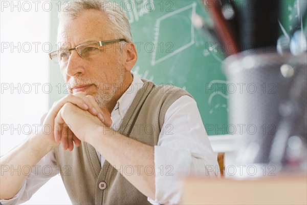 Focused old professor looking away classroom