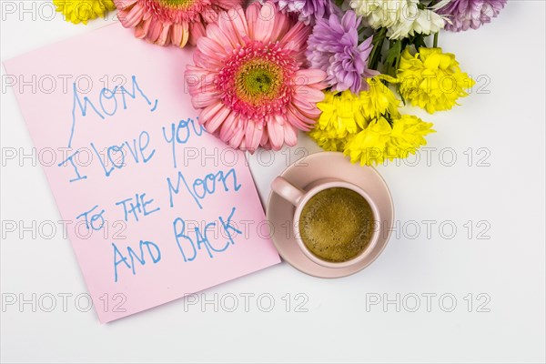 Fresh flowers near paper with words cup drink