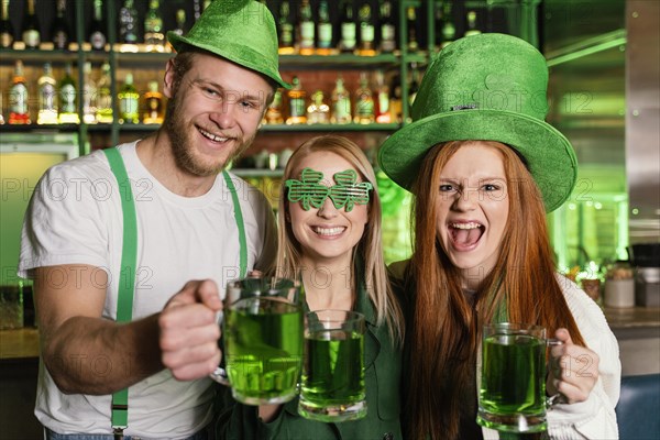 Front view group friends celebrating st patrick s day with drinks