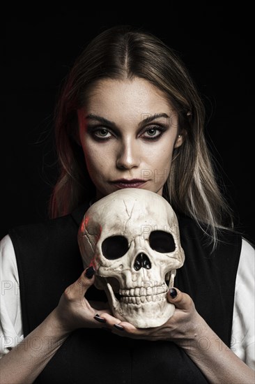 Front view woman holding human skull