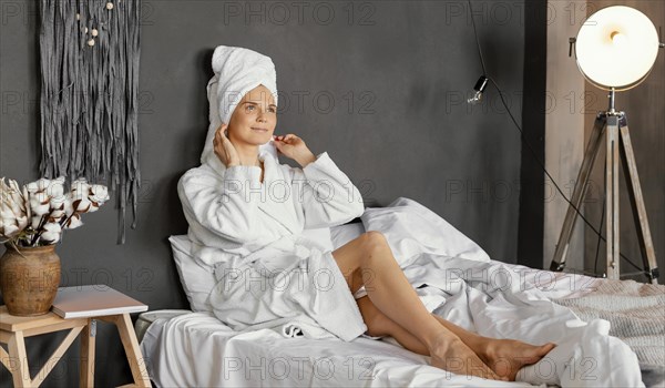 Full shot woman sitting bed