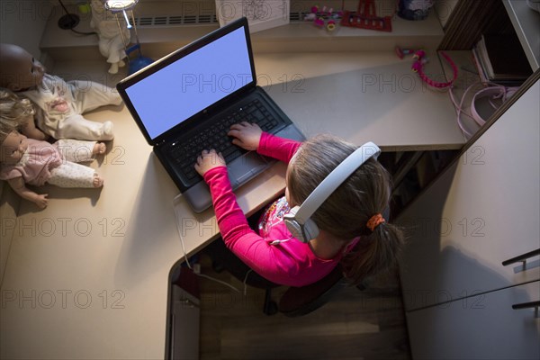 Girl using laptop small room