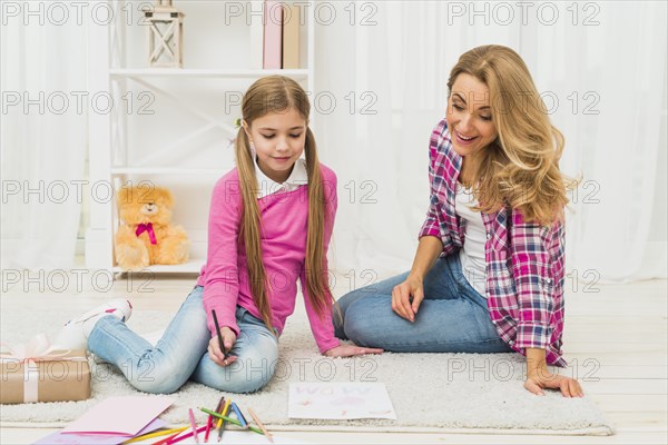 Girl with mother drawing paper floor