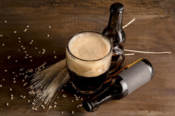 Glass beer foam with brown bottles beer wooden table