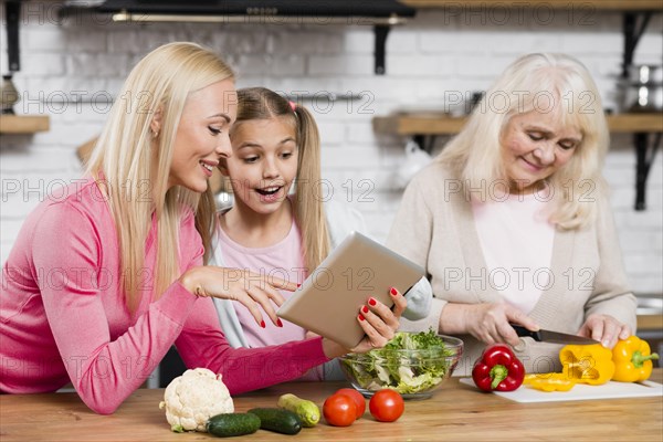 Grandma is cooking women are using tablet