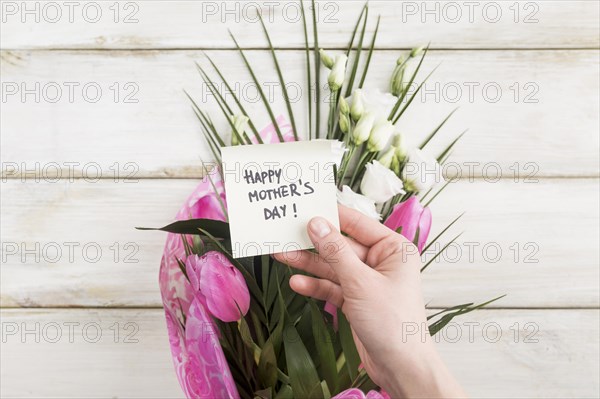 Hand with happy mothers day sticker bouquet