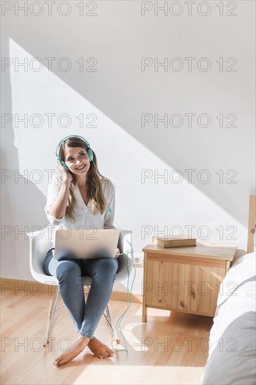 Happy young woman listening music laptop