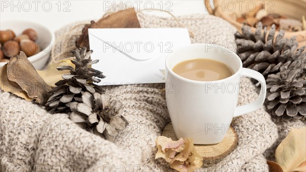 High angle coffee mug with autumn leaves pine cones