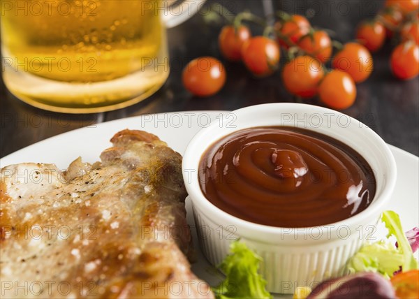 High angle steak plate with ketchup beer