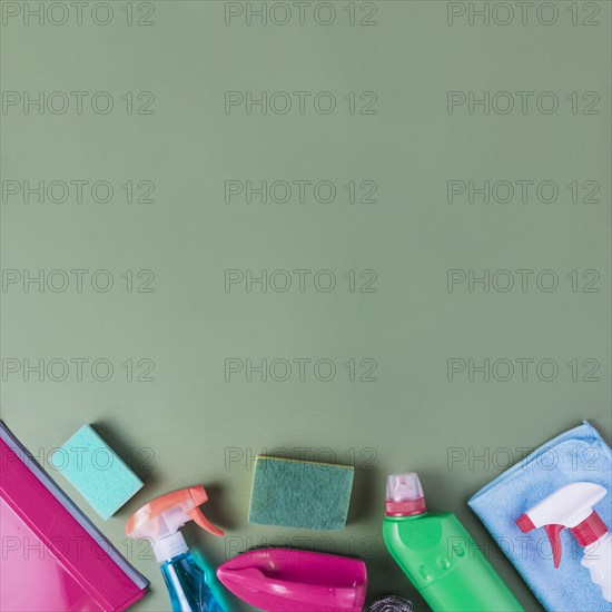 High angle view cleaning supplies green background