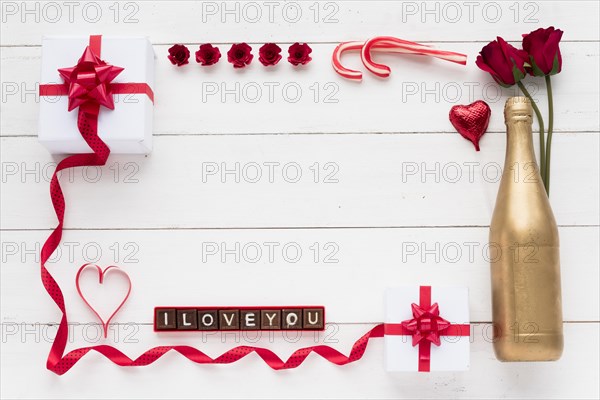 I love you inscription chocolate pieces near presents flowers bottle