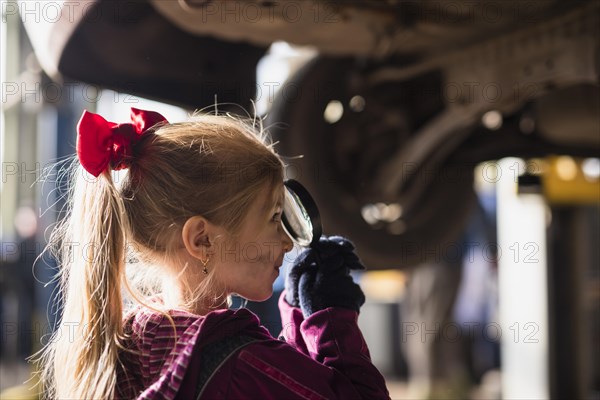 Little girl looking through magnifier