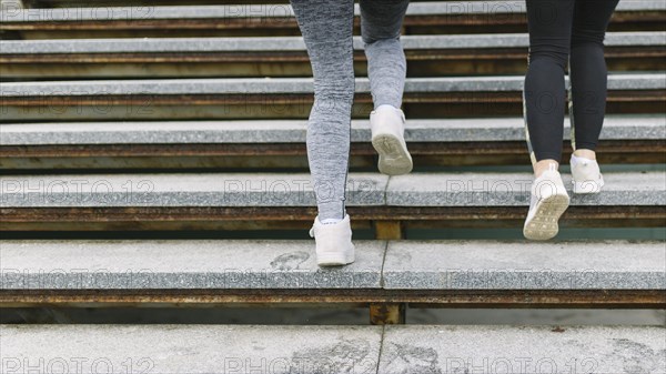Low section two female runner jogging staircases