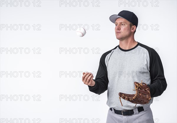 Man playing with baseball holding glove